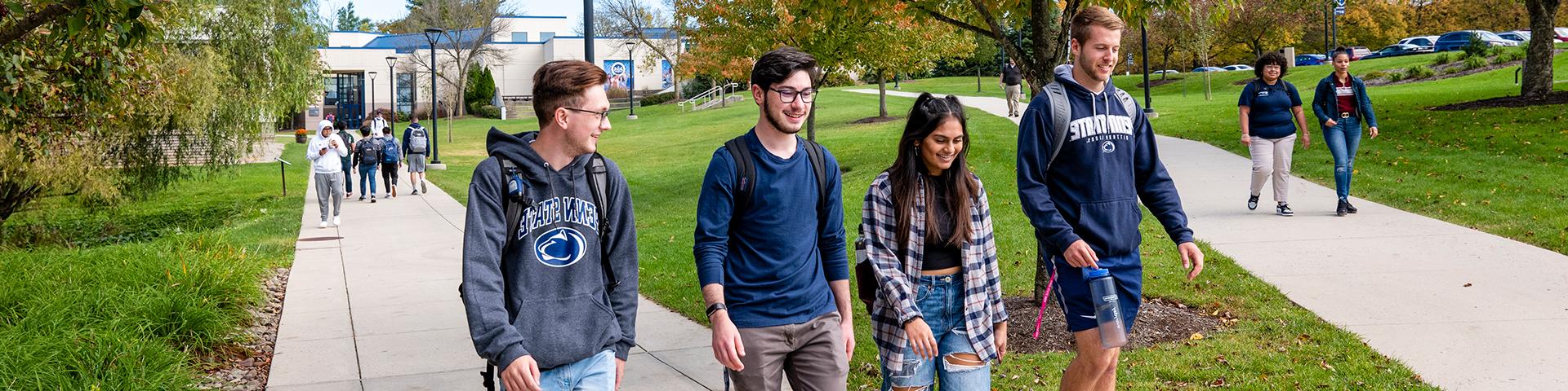 Students walking towards the camera on campus from the Gaige Building